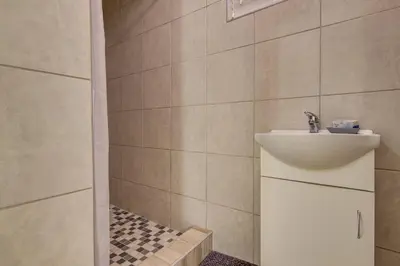a bathroom with a sink and a shower at Ovendales Self Catering Cottage in Benoni