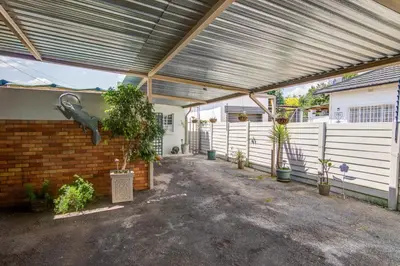 a garage with a metal roof and a brick wall at Ovendales Self Catering Cottage in Benoni