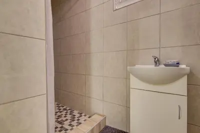 a bathroom with a sink and a shower at Ovendales Self Catering Cottage in Benoni