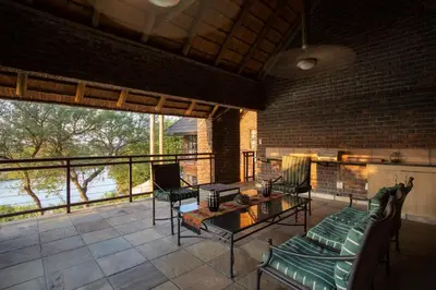 a living room with a couch and a fireplace at Hippo Hills Lodge Ngwenya in Marloth Park