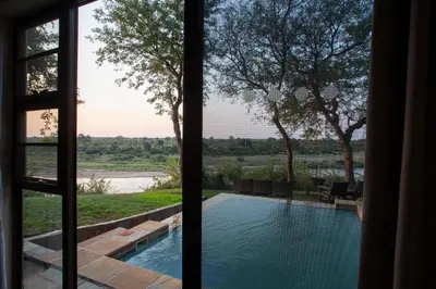 a view of a swimming pool from a window at Hippo Hills Lodge Ngwenya in Marloth Park