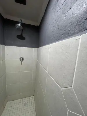 a bathroom with a tiled shower with a fan at Ha-Dzibs backpackers accommodation in Thohoyandou