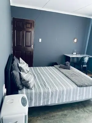 a bedroom with a bed with a table and a table at Ha-Dzibs backpackers accommodation in Thohoyandou