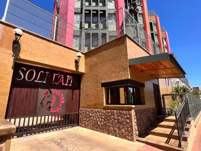 a restaurant with a sign on the side of a building at Solitaire Guest Apartments in Pretoria