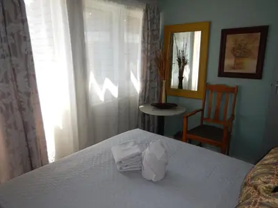 a bedroom with a bed with towels on it at Solitaire Guest Apartments in Pretoria