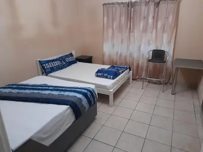 a bedroom with two beds and a table and a chair at Cozy guesthouse springs in Springs
