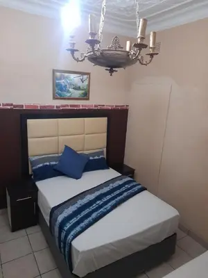 a bedroom with a bed with blue pillows and a chandelier at Cozy guesthouse springs in Springs