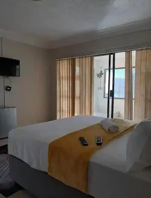 a bedroom with a large bed with two remote controls on it at Brovad Guesthouse in Kempton Park