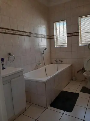 a bathroom with a tub and a sink and a toilet at Brovad Guesthouse in Kempton Park