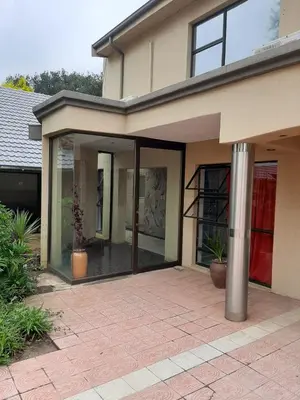 a house with sliding glass doors on a patio at Brovad Guesthouse in Kempton Park
