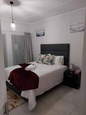 a bedroom with a bed with white sheets and pillows at Craiden Holiday Apartment at The Blyde Crystal Lagoon 2 bedrooms in Pretoria