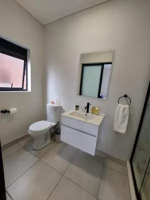 a white bathroom with a toilet and a sink at Craiden Holiday Apartment at The Blyde Crystal Lagoon 2 bedrooms in Pretoria