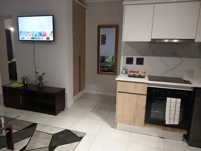 a kitchen with a stove and a tv on the wall at Craiden Holiday Apartment at The Blyde Crystal Lagoon 2 bedrooms in Pretoria