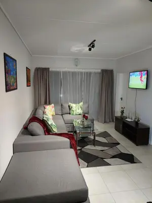 a living room with a couch and a tv at Craiden Holiday Apartment at The Blyde Crystal Lagoon 2 bedrooms in Pretoria