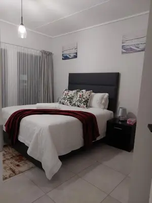 a bedroom with a large bed with a black headboard at Craiden Holiday Apartment at The Blyde Crystal Lagoon 2 bedrooms in Pretoria