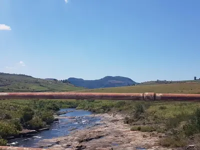 an old rusty bridge over a river at Lisbon Eco Lodge in Graskop