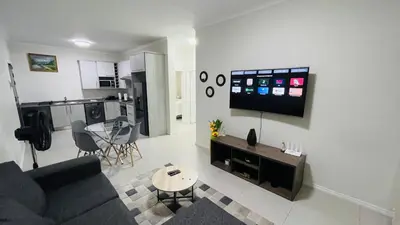 a living room with a couch and a tv on a wall at 92 On New By Damo in Midrand