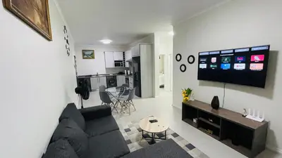 a living room with a couch and a tv on a wall at 92 On New By Damo in Midrand