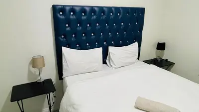 a bedroom with a large bed with a blue headboard at 92 On New By Damo in Midrand