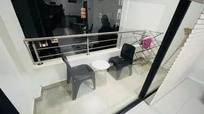 a balcony with chairs and a table and a window at 92 On New By Damo in Midrand
