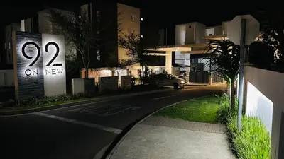 a street at night with a sign that says on new at 92 On New By Damo in Midrand