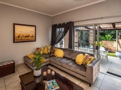 a living room with a couch and a table at Dew Drop Inn in Nelspruit