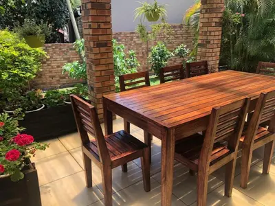 a wooden table and chairs on a patio at Dew Drop Inn in Nelspruit