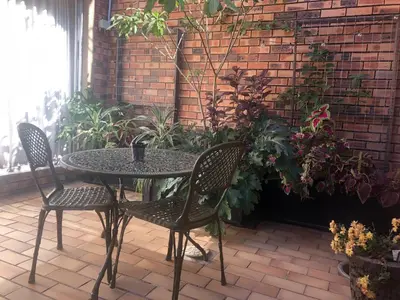 a table and chairs on a patio with plants at Dew Drop Inn in Nelspruit