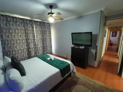 a bedroom with a bed and a flat screen tv at Sabie House -3 bedrooms, OR Tambo, Kempton Park, Johannesburg in Kempton Park