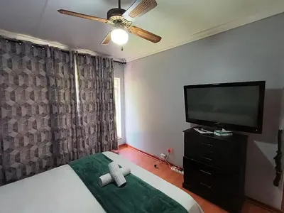 a bedroom with a bed and a flat screen tv at Sabie House -3 bedrooms, OR Tambo, Kempton Park, Johannesburg in Kempton Park