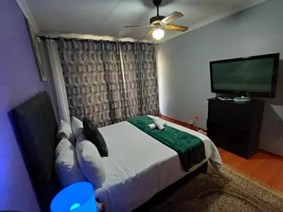 a bedroom with a bed and a flat screen tv at Sabie House -3 bedrooms, OR Tambo, Kempton Park, Johannesburg in Kempton Park