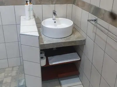 a bathroom with a sink and a counter with towels at Marloth Cottage in Marloth Park