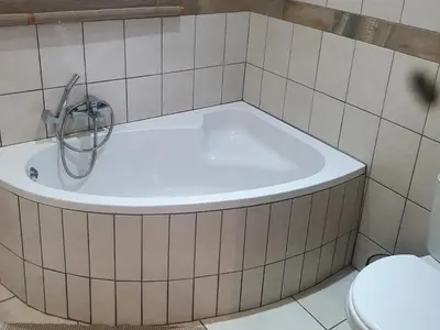 a bath tub in a bathroom with a toilet at Marloth Cottage in Marloth Park