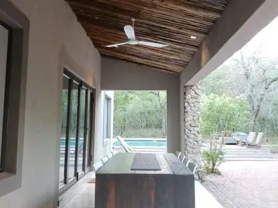 a patio with a table and a ceiling fan at Marloth Cottage in Marloth Park