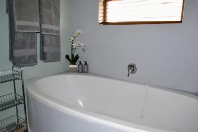 a white bath tub in a bathroom with a window at Cherry Grove 2 in Dullstroom