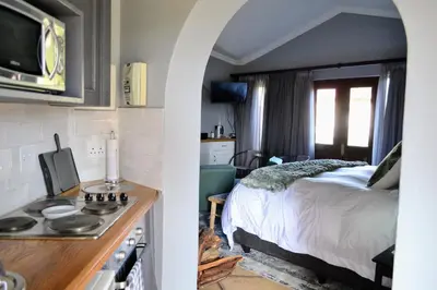 a kitchen and a bedroom with a bed in a room at Cherry Grove 2 in Dullstroom