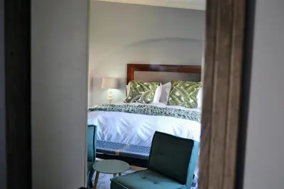 a bedroom with a bed and a chair and a desk at Cherry Grove 2 in Dullstroom