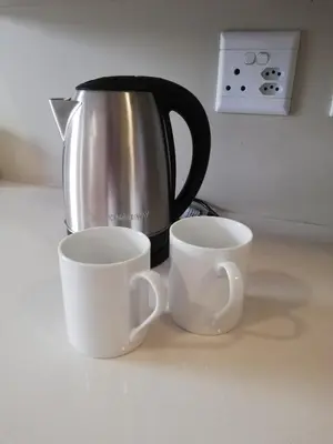 two cups sitting on a counter next to a coffee pot at Gallagher Midrand BnB in Midrand