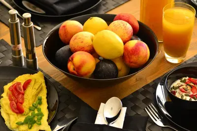 a table with a bowl of fruit and a bowl of food at Zebra Cottage in Pretoria