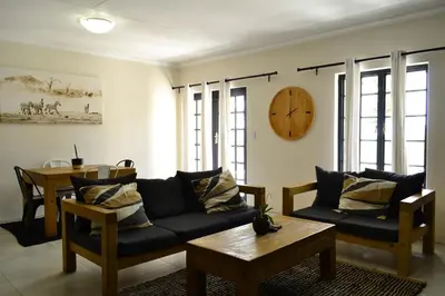 a living room with a couch and a table at Zebra Cottage in Pretoria
