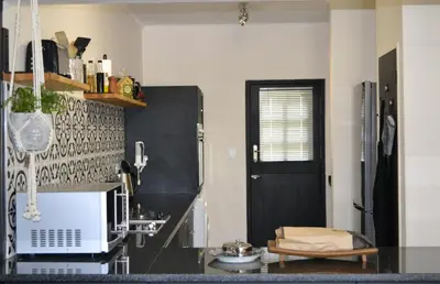a kitchen with a black door and a black counter at Zebra Cottage in Pretoria
