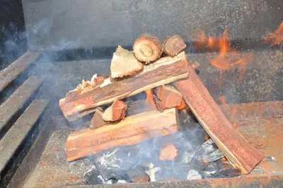 a pile of wood on a grill with flames at Zebra Cottage in Pretoria