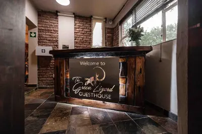 a welcome to the creamfield guest house sign on a wall at The Green Lizard Guesthouse in Nelspruit