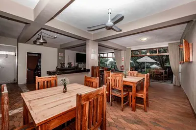 a dining room with wooden tables and chairs at The Green Lizard Guesthouse in Nelspruit