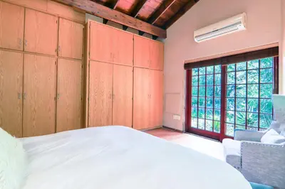 a bedroom with a bed and a large window at Brooklyn's Holiday Home in Pretoria