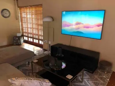 a living room with a flat screen tv on the wall at Brooklyn's Holiday Home in Pretoria
