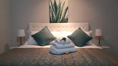 a bed with a pile of towels on it at Lesolo Lodge in Burgersfort