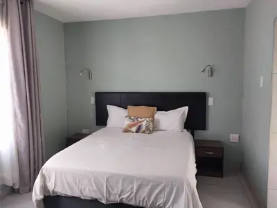 a bedroom with a bed with a cat pillow on it at Lesolo Lodge in Burgersfort