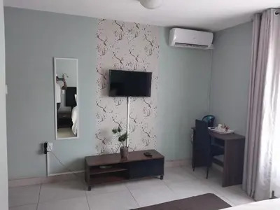 a living room with a tv on a wall at Lesolo Lodge in Burgersfort