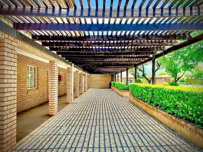 a brick walkway with awning in a building with plants at Lesolo Lodge in Burgersfort